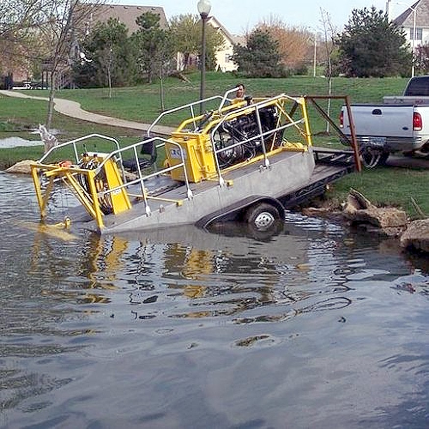 Small hydraulic dredge being launched into a pond